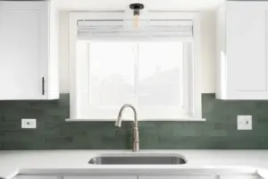 A porcelain countertop in a Springville, UT kitchen with a green backsplash 