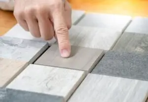 A closeup of a person pointing at stone material samples for countertops in Springville, UT.