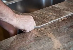 A countertop installer is installing a granite countertop showing the seam in Springville, UT.