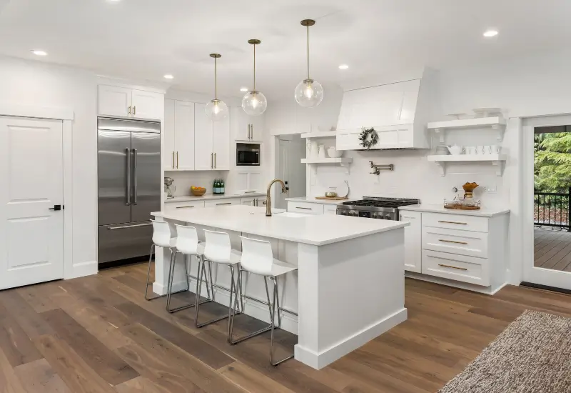 A white kitchen counter and island with white cabinets in a Springville, UT home.